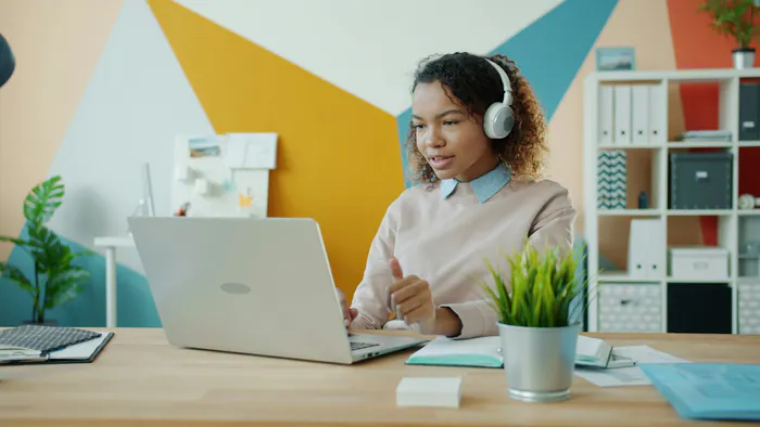 Woman wearing headphones while using a laptop